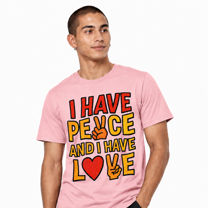 Male model wearing a light pink graphic T-shirt featuring “I HAVE PEACE AND I HAVE LOVE” comic-style artwork
